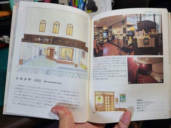 The Illustrated Guide book open to the page about Cinekoya, showing photos of the interior of the theater, the downstairs book-cafe, and velvet seats of the waiting area